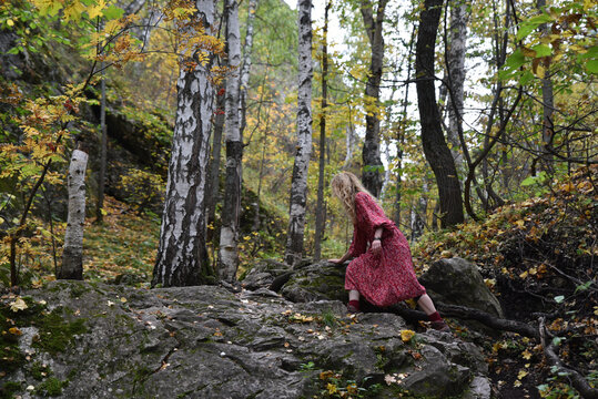 Young woman climbing rocky terrain in a forest