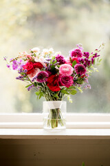 Vertical image of vivid bridal bouquet on windowsill