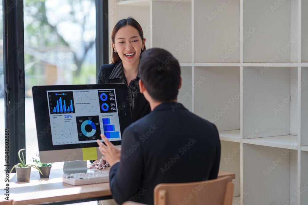 Poster two asian businesspeople are discussing business performance using charts and data displayed on a co