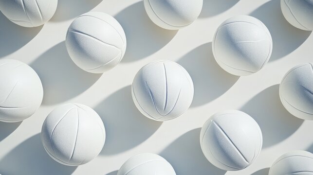 Close-up of white leather volleyballs on indoor wooden court floor, ideal for team sports, athletic training, volleyball practice, and indoor gym equipment concepts
- Powered by Adobe
