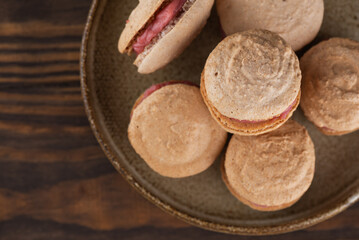 Vegan homemade caramel macarons with raspberry cream on shea butter. Sugar, lactose and gluten free. Top view.