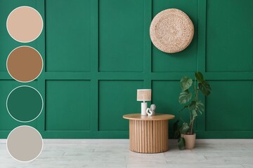 Wooden table with lamp, houseplant and decor near green wall. Different color patterns