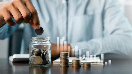A person is putting coins into a piggy bank. retirement, earnings, financial, loan, economic, finance, wealth, piggy bank, assurance, future. Concepts of saving money and financial planning. 