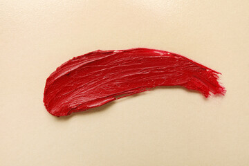 Red lipstick stroke on beige background