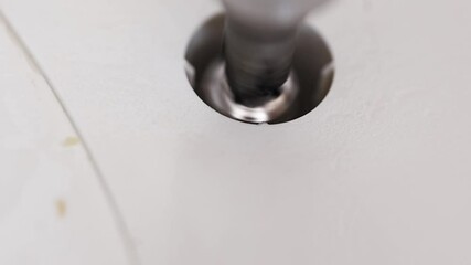 Master repairs household equipment by removing screw from thermopod