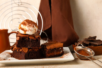 Plate with pieces of tasty chocolate brownie and ice cream on light background