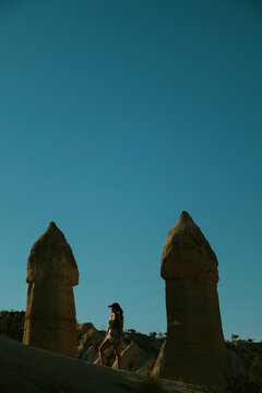 Woman staring at the sun between rock formations in Cappadocia