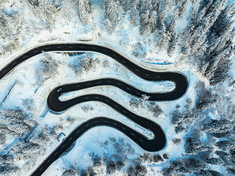 Car traveling on hairpin bends of a snowy  mountain road