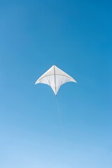 White Kite Soaring High Against a Clear Blue Sky on a Sunny Day