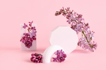 Obraz premium Lilac flowers with plastic figures on pink background