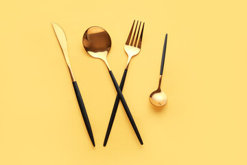 Stylish cutlery on yellow background