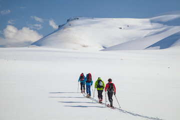 Ski mountaineers trekking through the Armenian mountains in early spring. The vast snowfields...