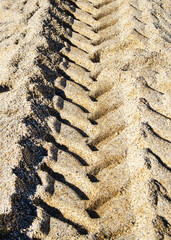 Tire Tracks quad bike on Sandy Surface Creating a Pattern