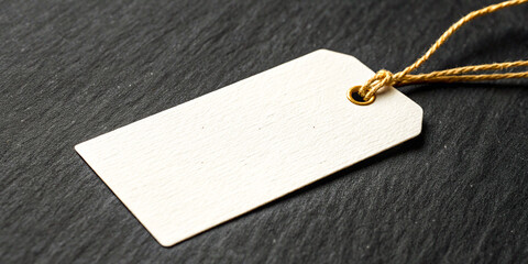 White rectangular tag, gold string, blank label, dark slate background, product photography, minimalist, closeup, high contrast, textured surface, clean design, elegant, retail, marketing, branding