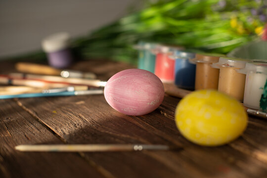 Table with paint and brush for painting easter eggs