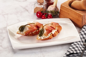 Bruschetta with jamon and caper berries