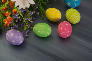 Colorful easter decoration with and flowers on gray wooden table. Top view