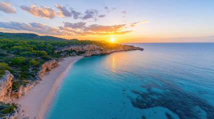 Aerial view of secluded beach at sunrise with golden hues reflecting on water