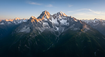 Obraz premium Majestic Mountain Peaks Bathed in Golden Light at Dawn or Sunset