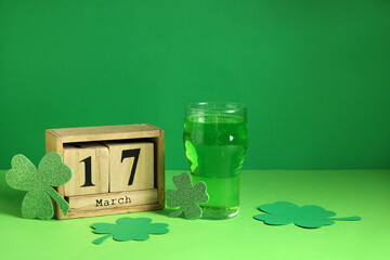 Cube calendar with date 17 MARCH and glass of beer on green background. St. Patrick's Day...