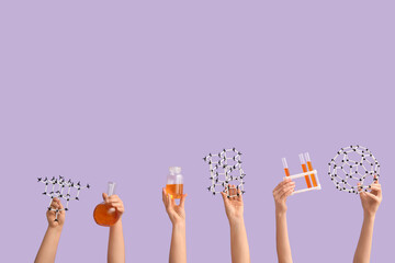 Female hands holding filled flask with bottle, test tubes and molecular models on lilac background....