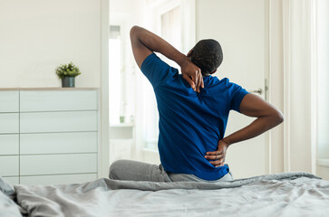 Rear View Of African American Man Touching And Massaging Aching Neck And Spine Suffering From Pain...