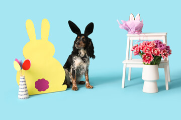 Cute cocker spaniel in bunny ears with beautiful tulips, Easter paper eggs and rabbit on blue...