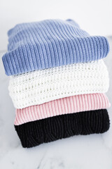 pile of sweaters and knits in different color fabric neatly folded and piled up