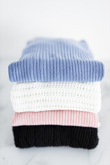 pile of sweaters and knits in different color fabric neatly folded and piled up