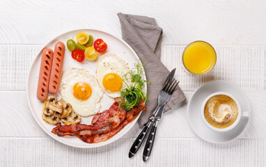 A classic breakfast plate featuring sunny-side-up eggs, crispy bacon, sausages, and fresh tomatoes