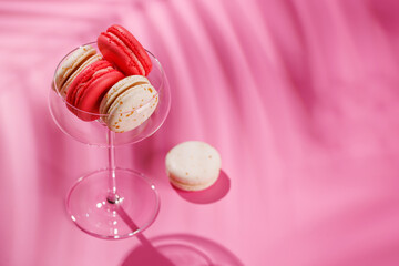 A delightful assortment of colorful macaroons arranged on a vibrant pink background