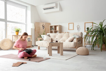 Young woman with Sadhu board playing glucophone at home