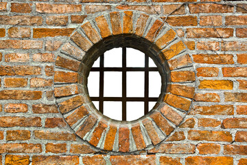Round window on old and weathered brick wall with metal grate - Freedom concept