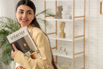 Beautiful young happy woman with magazine at home