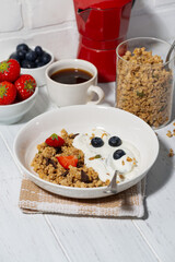 breakfast with crunchy granola, greek yogurt and fresh berries, vertical