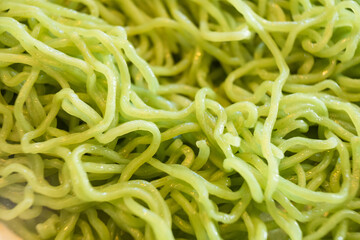 Close-up of vibrant green noodles showcasing their texture and freshness, ideal for culinary and food photography usage