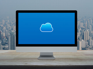 Cloud computing icon on desktop modern computer monitor screen on wooden table over office building tower and skyscraper in city, Technology cloud computing concept