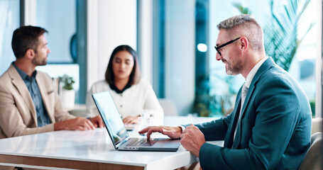 Fototapeta premium Meeting, businessman and ceo with laptop in office, financial report and review for corporate firm. Service, mature person and consultant with tech for investment research, reading and online for faq