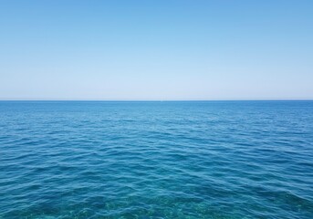 Obraz premium Ocean with turquoise surface glistening in sunlight with clear horizon reflecting cloudless sky creating tranquil nautical scenery, for vacation and summer postcard