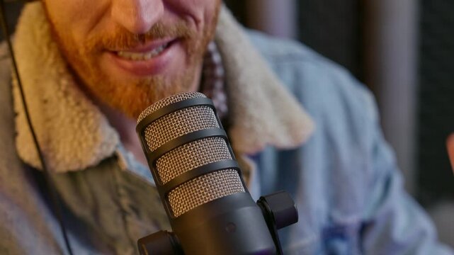 Close up on radio or podcast host adjusting microphone and speaks in sound studio. Young man's hands set mic close to his mouth. Recoding in professional audio room a live streaming podcast show