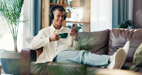 Home, man and coffee with smartphone for music, wellness and comfortable on sofa in morning. House,...
