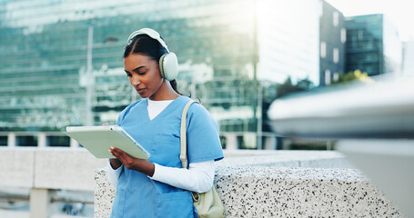 Nurse, city and woman on tablet with headphones for education, audiobook or wellness podcast....