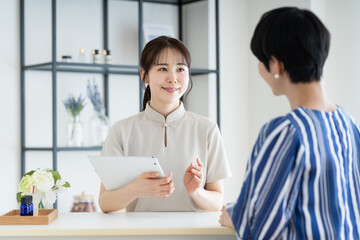 若い女性のカウンセリングをするエステサロンのスタッフ
