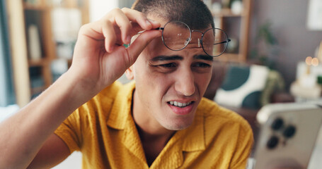 Frustrated man, phone and glasses with eye strain for wrong frame, optometry prescription or sight at home. Male person, reading and issues with spectacles or lens on mobile smartphone for bad vision