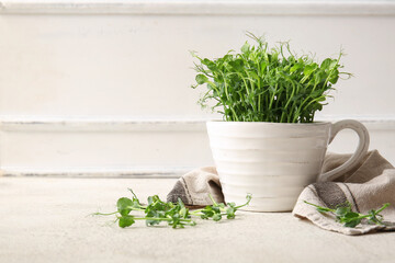 Ceramic cup with fresh micro green sprouts and napkin on light table