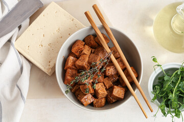 Bowl with pieces of fried tofu cheese, thyme and micro green on white background