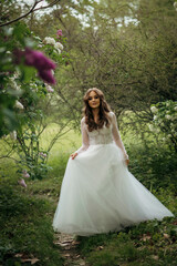 Fototapeta premium young beautiful girl bride in elegant wedding dress in park