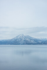 Serene snowy mountain vista reflecting on calm winter lake