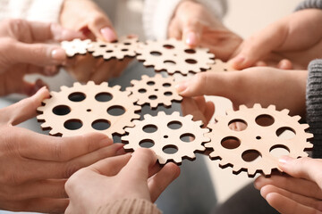 Group of people holding wooden gears