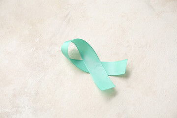 Turquoise ribbon on light grunge background. Cervical Health Awareness Month